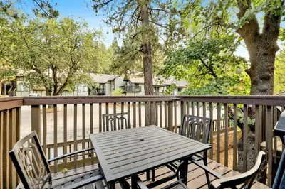 a wooden table and chairs on a wooden deck at Switzerland Summit Condo #2569 in Big Bear Lake