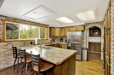 a kitchen with wooden cabinets and a kitchen island with chairs at Arlberg Village Haus #2571 in Big Bear Lake