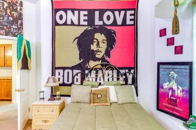a bedroom with a one love poster on the wall at 5 Mi to the Marketplace Roomy Bakersfield Retreat in Bakersfield