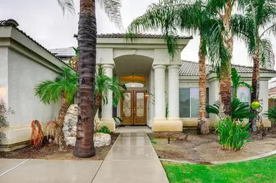 a house with palm trees in front of it at 5 Mi to the Marketplace Roomy Bakersfield Retreat in Bakersfield