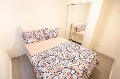 a small bedroom with a bed with a quilt at Cozy 2 Bedroom In Hollwood area Close to Downtown La in Los Angeles