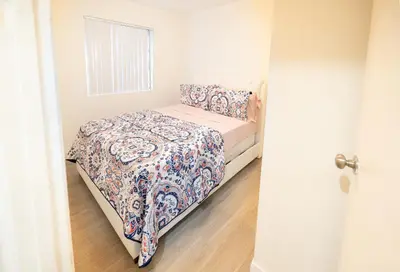 a small bedroom with a bed with a floral bedspread at Cozy 2 Bedroom In Hollwood area Close to Downtown La in Los Angeles