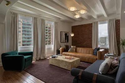 a living room with a couch and chairs and windows at Ocean-View 1BR Condo in Historic Cooper Arms in Long Beach