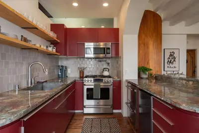 a kitchen with red cabinets and a stove top oven at Ocean-View 1BR Condo in Historic Cooper Arms in Long Beach