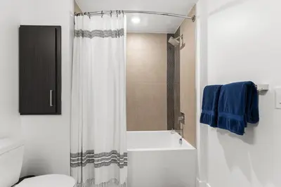 a bathroom with a shower curtain and a toilet at Sapphire Marina - Marina View Pool, Gym, Game Room in Los Angeles