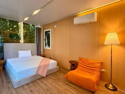 a bedroom with a bed and a lamp and a chair at Serene Glasshouse Retreat with Iconic LA Skyline Views in Los Angeles