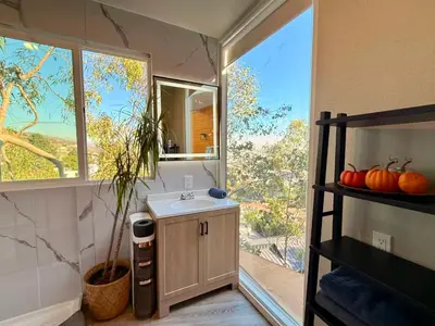 a bathroom with a sink and a large window at Serene Glasshouse Retreat with Iconic LA Skyline Views in Los Angeles