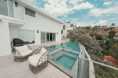 a balcony with two chairs and a swimming pool at Serene Glasshouse Retreat with Iconic LA Skyline Views in Los Angeles