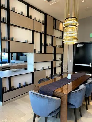 a dining room with a large wooden table and blue chairs at DTLA Luxury Studio in Los Angeles