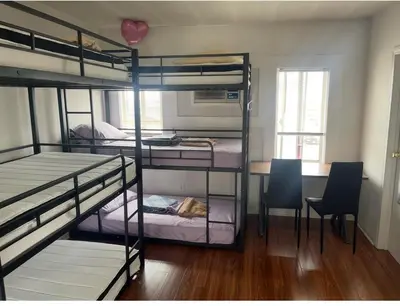 a room with three bunk beds and a table and chairs at Bunk beds in Los Angeles