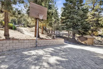 a basketball hoop on a brick wall in a park at Round Rock Lodge at Big Bear Boulder Bay Modern Retreat w/ Pool Table Minutes to Activities in Big Bear Lake