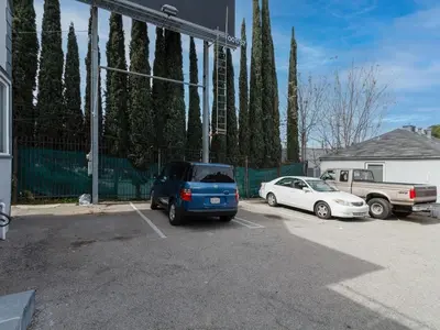 two cars parked in a parking lot next to a fence at Cozy Studio, Studio City Unit 2 in Los Angeles
