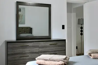a bedroom with a dresser with a mirror on it at SMA Apartment in Los Angeles