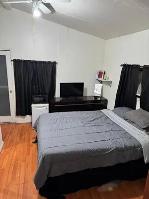 a bedroom with a large bed and a desk at Cozy Private Room Near Disneyland, Beaches & Downtown LA in Artesia