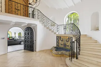 a staircase in a home with a wrought iron railing at One of Kind Ultra Luxury Beverly Hills Estate in Los Angeles