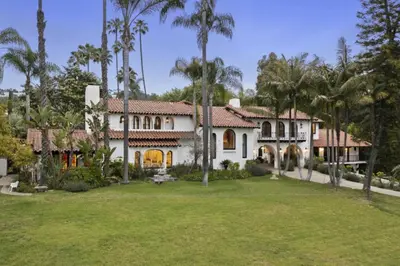 an exterior view of a house with palm trees at One of Kind Ultra Luxury Beverly Hills Estate in Los Angeles