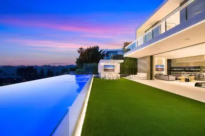 a large house with a yard of green grass at Ultra-Luxurious BH Estate with Pool, Theatre, Views in Beverly Hills