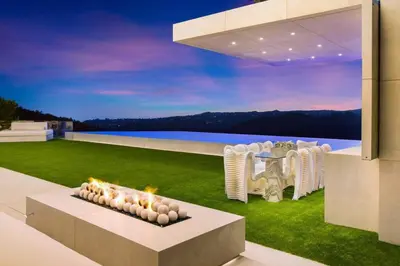 a house with a lawn with a table and chairs at Ultra-Luxurious BH Estate with Pool, Theatre, Views in Beverly Hills