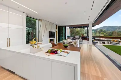 an open kitchen and living room with a view of the backyard at Luxurious 5BR Villa in BH with Pool, Theater, and Views in Los Angeles