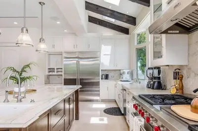 a kitchen with white cabinets and stainless steel appliances at Summitridge Bev Hills Villa with Pool, Spa, Roof Deck in Beverly Hills