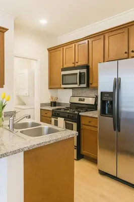 a kitchen with stainless steel appliances and wooden cabinets at Holiday in LA- Koreatown Retreat with Free Parking, Pool and Sauna in Los Angeles