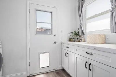 a white kitchen with a white door and a window at Pool House Retreat near LAX, SoFi & Beach in Inglewood
