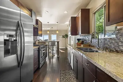 a large kitchen with stainless steel appliances and wooden cabinets at LA Chic Stunning Views & Sunsets in Los Angeles