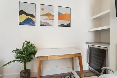 a living room with a table and a tv at Charming Modern apartment in Santa Monica in Los Angeles