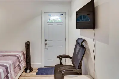 a bedroom with a bed and a television and a chair at Work and Play! North Hills Studio 15 Mi to Hollywood in North Hills
