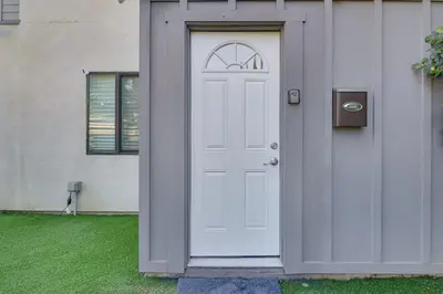 a white door next to a white house at Work and Play! North Hills Studio 15 Mi to Hollywood in North Hills