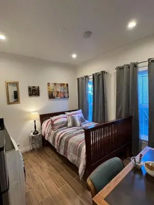 a bedroom with a bed and a table in it at Charming Studio Near DTLA AC WiFi Snacks in Los Angeles