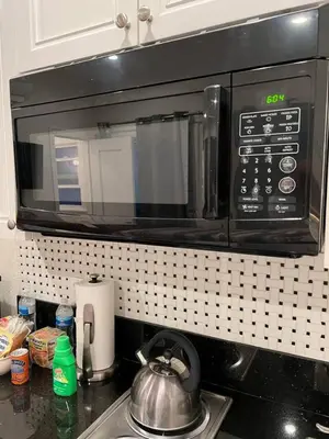 a microwave above a kitchen counter with a sink at Charming Studio Near DTLA AC WiFi Snacks in Los Angeles