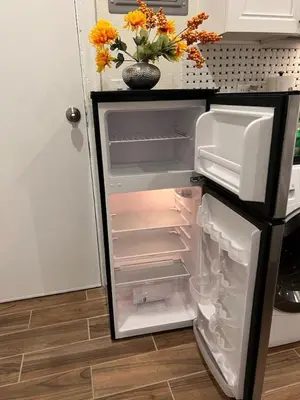 a refrigerator with its door open and a vase with flowers at Charming Studio Near DTLA AC WiFi Snacks in Los Angeles