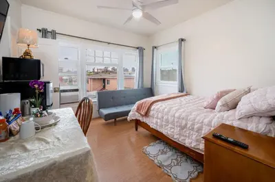 a bedroom with a bed and a couch and a table at Comfy Studio Near Downtown LA with AC WiFi and Snacks in Los Angeles