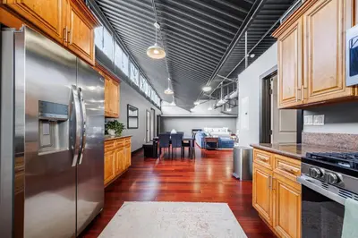 a kitchen with a stainless steel refrigerator and wooden cabinets at Long Beach Apartment - 10 Min Walk to the Beach! in Long Beach