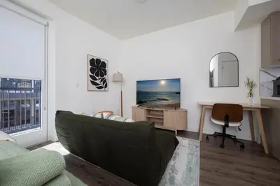 a living room with a couch and a desk at Beautiful NEW apartment in SM! in Los Angeles