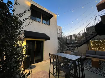 a patio with a table and chairs and a staircase at Lalaland Bungalow in Burbank