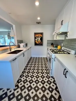 a kitchen with a black and white checkered floor at Lalaland Bungalow in Burbank