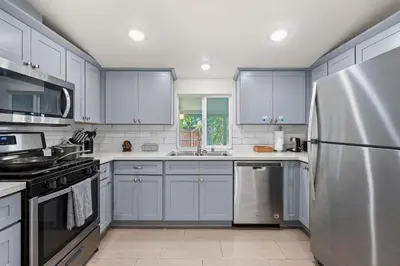 a kitchen with blue cabinets and a stainless steel refrigerator at Foothills LA Hideaway Patio Lounge Work-Friendly in Glendora