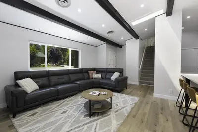 a living room with a black couch and a table at Bear Mountain Getaway in Big Bear Lake