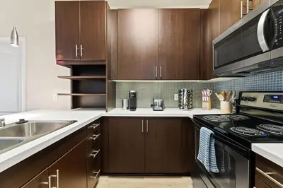 a kitchen with wooden cabinets and a stove top oven at Great 2bd 2bath in MdR! Free parking and pool! in Los Angeles