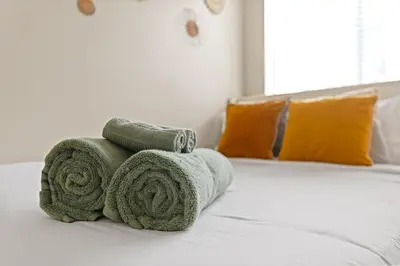 a pile of towels sitting on top of a bed at Great 2bd 2bath in MdR! Free parking and pool! in Los Angeles