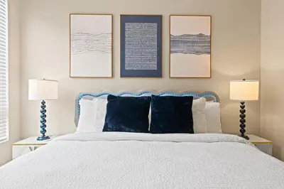 a bedroom with a bed with three pictures on the wall at Great 2bd 2bath in MdR! Free parking and pool! in Los Angeles