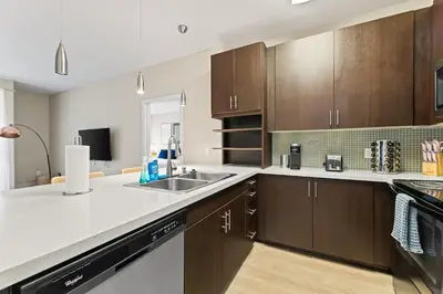 a kitchen with wooden cabinets and a sink at Great 2bd 2bath in MdR! Free parking and pool! in Los Angeles