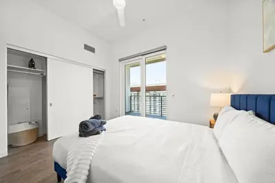 a white bedroom with a large bed and a tub at Cozy Beachside Escape with Great Views in Long Beach