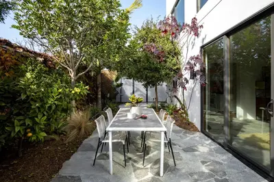 a patio with a table and chairs in a garden at Abbot Kinney 2-Story Bungalow with Sauna and Plunge in Los Angeles