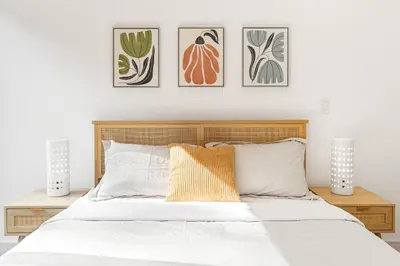 a bedroom with a bed with four pictures on the wall at Luna View LA in Los Angeles