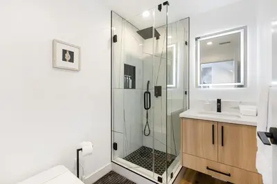 a bathroom with a glass shower and a sink at Luna View LA in Los Angeles