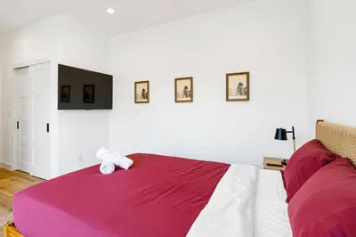 a bedroom with a large bed and a tv on the wall at Luna View LA in Los Angeles