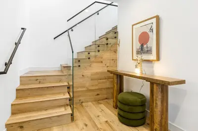 a staircase with a green ottoman and a wooden table at Luna View LA in Los Angeles